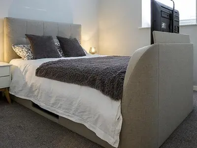 a bedroom with a large bed with a television on it at The Lane Apartment in Edinburgh