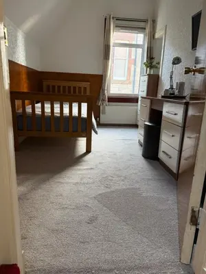 a bedroom with a bed and a desk and a window at Hillhouse in Edinburgh