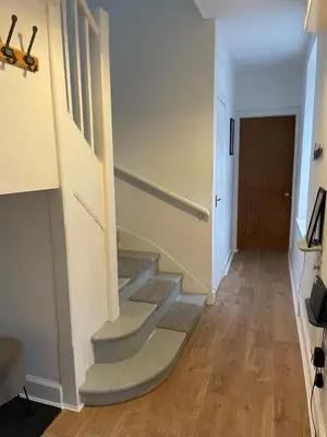 a hallway with stairs leading up to a door at Lovely house next to Euchan River in Sanquhar