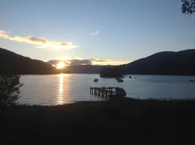 a sunset over a body of water with boats at The Garden Flat in Crieff
