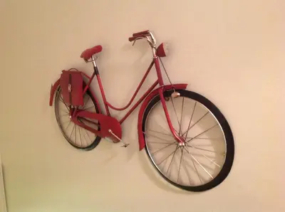 a red bike is hanging on a wall at The Garden Flat in Crieff