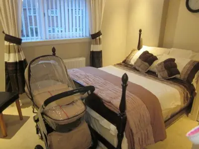 a bedroom with a bed and a baby stroller at Three Bridges Bed & Breakfast in Rosyth