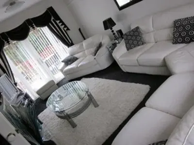 a living room with a white couch and a table at Three Bridges Bed & Breakfast in Rosyth