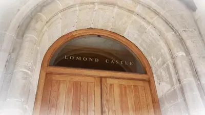 a wooden door with the words normal castle above it at The Pipers No 7 Lomond Castle in Balloch