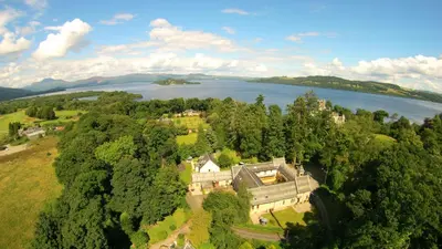 an aerial view of a mansion with a lake at Coachouse in Balloch
