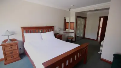 a bedroom with a large white bed and a night stand at Coachouse in Balloch