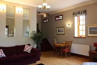 a living room with a couch and a table at Stables Lodge in Balloch