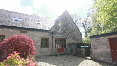 an old stone house with a brick yard at Stables Lodge in Balloch