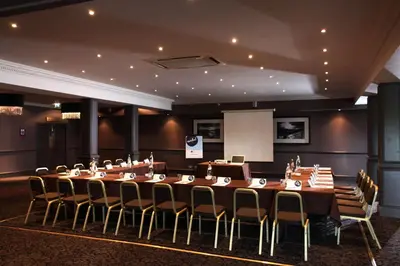 a conference room with a long table and chairs at Best Western Garfield House Hotel in Chryston