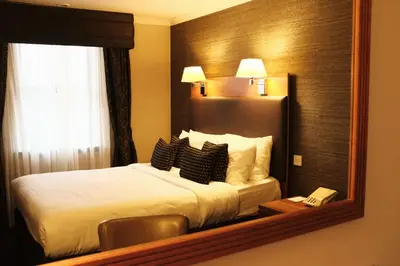 a hotel room with a bed and a mirror at Best Western Garfield House Hotel in Chryston