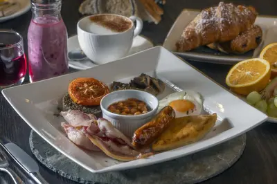 a plate of breakfast food with eggs bacon beans and nuts at Best Western Garfield House Hotel in Chryston