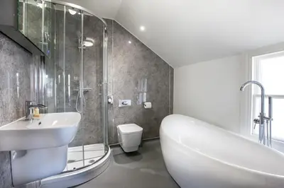 a bathroom with a tub and a sink and a shower at Black Bull Inn, Moffat in Moffat