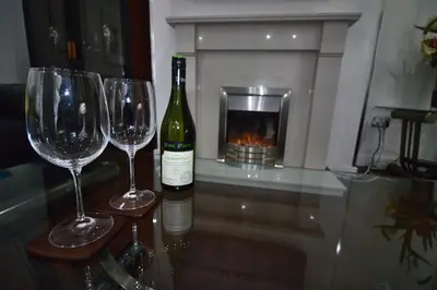 a bottle of wine and two wine glasses on a table at The Marlfield in Bellshill