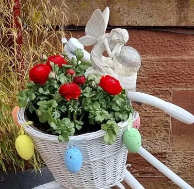a basket of flowers with an angel sitting on a bike at St Leonards Guest House in Largs