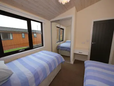 a bedroom with two beds and a large window at Chalet Loch Leven Lodge by Interhome in Ballingry