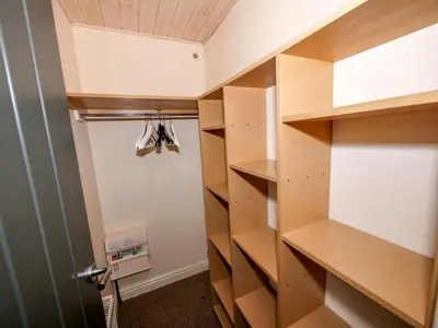 a walk in closet with wooden shelves and a door at Chalet Loch Leven Lodge by Interhome in Ballingry
