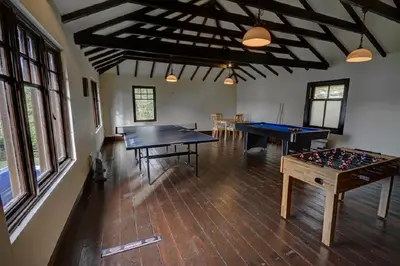 two ping pong tables in a room with windows at Chapelhill in Helensburgh