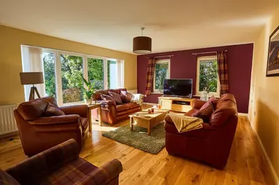 a living room with two couches and a tv at Chapelhill in Helensburgh