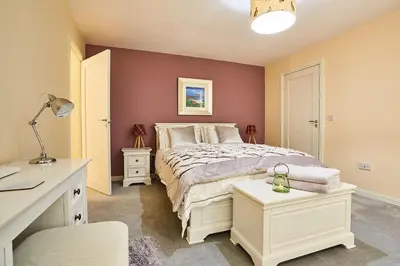 a bedroom with a white bed and a desk and a chair at Chapelhill in Helensburgh