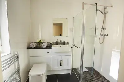 a white bathroom with a sink and a shower at Chapelhill in Helensburgh