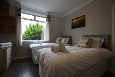 two beds in a bedroom with a window at Sighthill 3 Bedrooms with Private Garden in Edinburgh