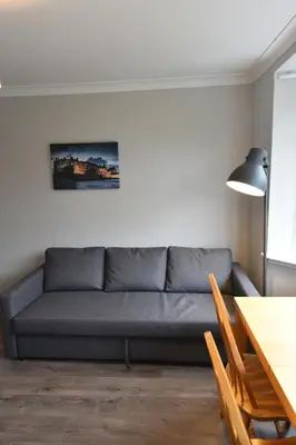 a living room with a couch and a table at Sighthill 3 Bedrooms with Private Garden in Edinburgh