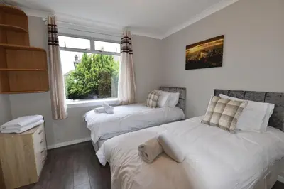 a bedroom with two beds and a window at Sighthill 3 Bedrooms with Private Garden in Edinburgh