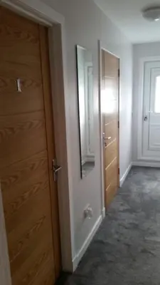 an empty room with a door and a mirror at Newtown Apartments in Boʼness