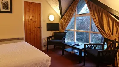 a bedroom with a bed and a desk and a window at The Four Seasons Hotel in Saint Fillans