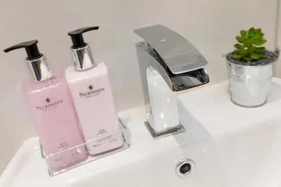 a sink with two soap bottles and a faucet at Lomond Serviced Apartments- Inglewood in Alloa