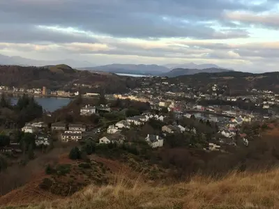 a town on a hill with a body of water at Inverasdale in Oban