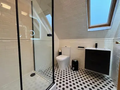 a bathroom with a toilet and a glass shower at Stob Binnein Cottage in Crianlarich