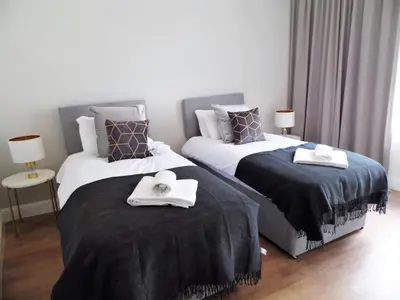 two beds with towels on them in a bedroom at Signature - Langlands House in Glasgow