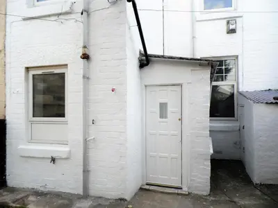 a white building with a white door and a window at Signature - Langlands House in Glasgow