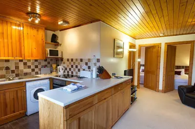 a kitchen with a sink and a dishwasher at Eagle Lodge with stunning loch and mountain view in Crianlarich