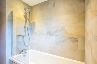 a bathroom with a shower and a tub and a sink at Gamekeeper Lodge loch and mountain view free wifi in Crianlarich