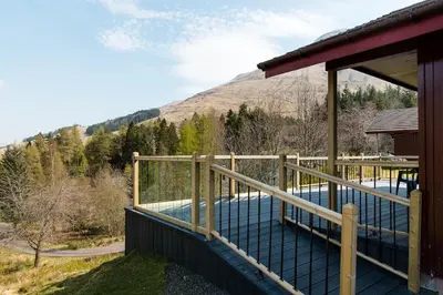 a balcony of a house with a swimming pool at Gamekeeper Lodge loch and mountain view free wifi in Crianlarich