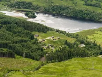 an aerial view of a valley with a lake and trees at Osprey Lodge with river and mountain view in Crianlarich