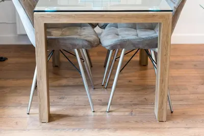 a glass table with four stools under it at Otter with mountain view and enclosed decking in Crianlarich