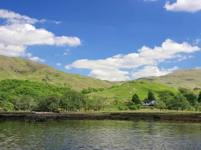 a body of water with mountains in the background at Invernoe Cottage in Taynuilt