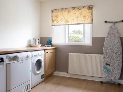 a laundry room with a washing machine and a window at High Ranachan in Campbeltown