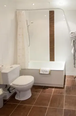 a bathroom with a toilet and a bath tub at South Beach Hotel in Troon