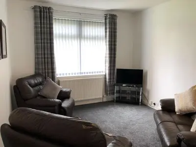 a living room with a couch and a television at Signature - Anderson View in Motherwell