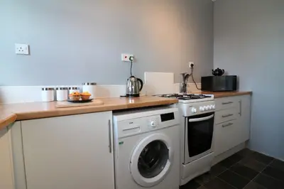a kitchen with a stove and a washing machine at Signature - Anderson View in Motherwell