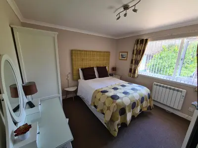 a bedroom with a bed and a window at Coel Ila in Benderloch