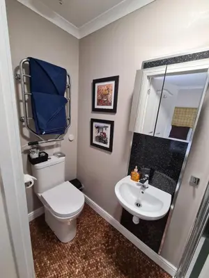 a bathroom with a white toilet and a sink at Coel Ila in Benderloch