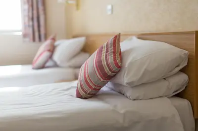 a bed with four pillows on top of it at Selborne Hotel in Dunoon