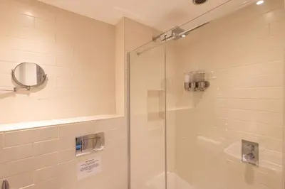 a shower with a glass door in a bathroom at Altskeith Country House in Aberfoyle