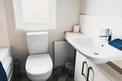 a bathroom with a white toilet and a sink at Atlas Ovation Lodge in Auchterarder