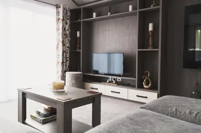 a living room with a tv and a bed and a table at Atlas Ovation Lodge in Auchterarder